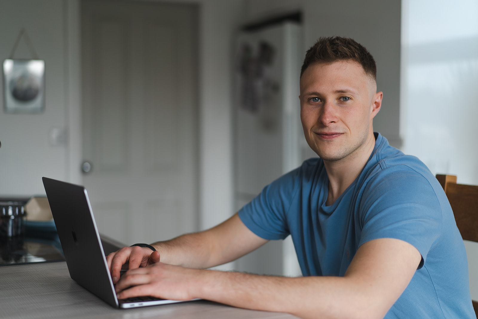 Joe David, founder of Optimise Health, sitting with his laptop